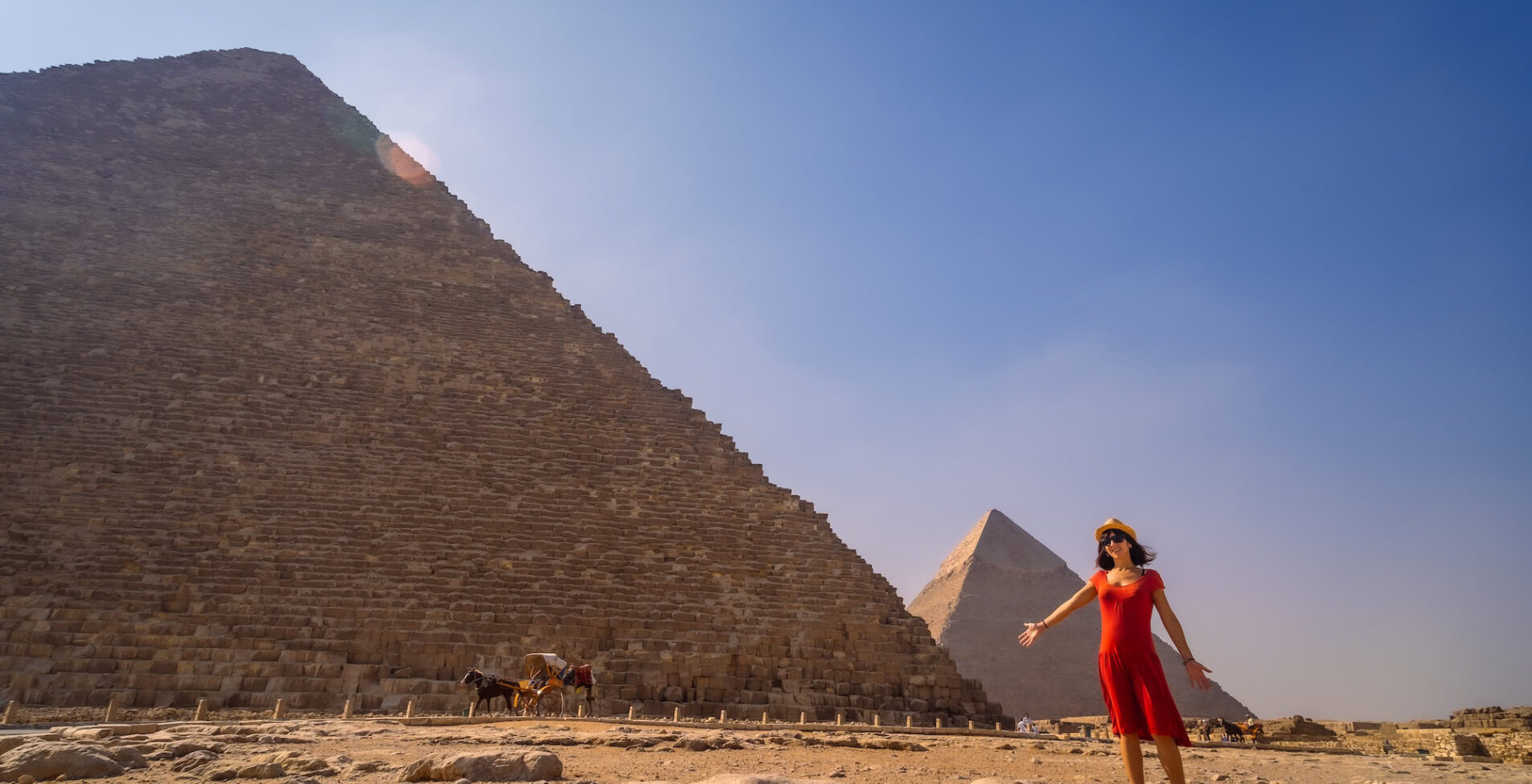 A young girl in a red dress at the pyramid of Cheops the largest pyramid. The pyramids of Giza