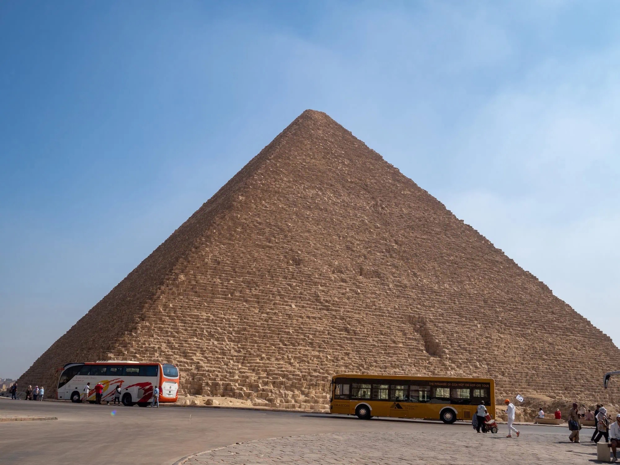 Tourist buses and visitors at the Great Pyramid of Giza during guided tour