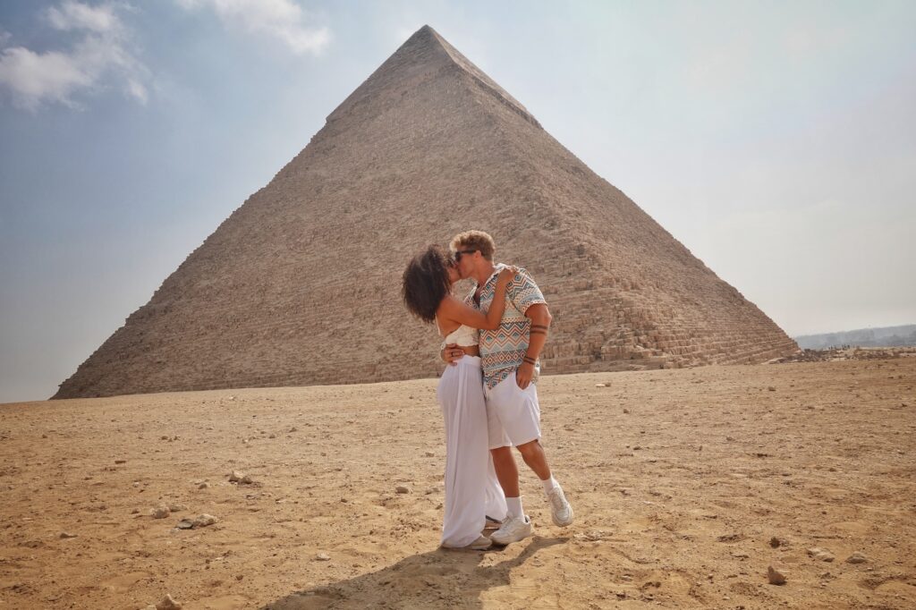 Couple kissing in front of a pyramid