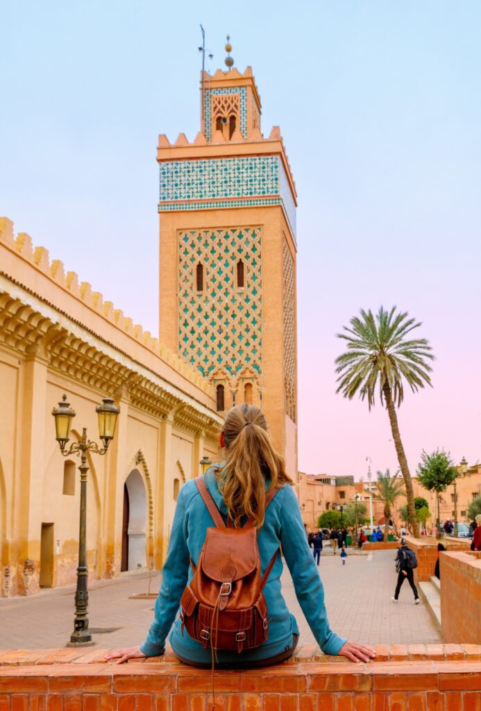 Woman sitting in front of the Koutoubia Mosque in Marrakech