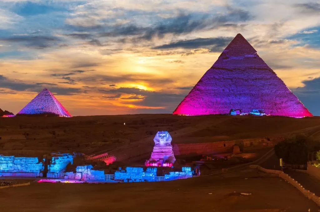 The Great Sphinx and the Pyramids of Giza dramatically illuminated in colored light during the evening Sound and Light Show