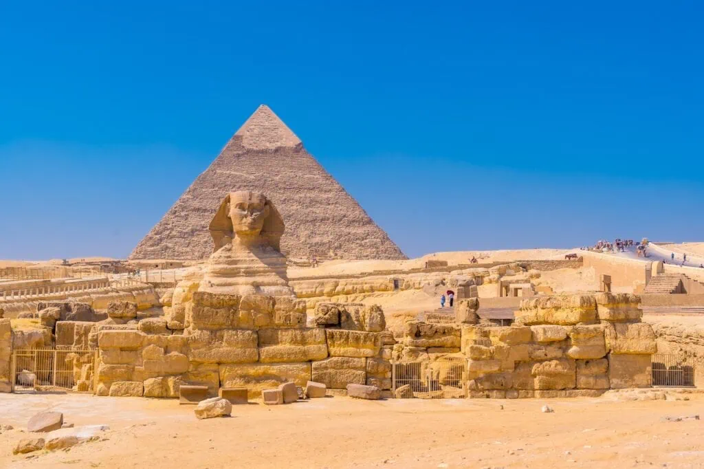 The Great Sphinx of Giza with the pyramid of Khafre rising behind it on the Giza plateau outside Cairo.