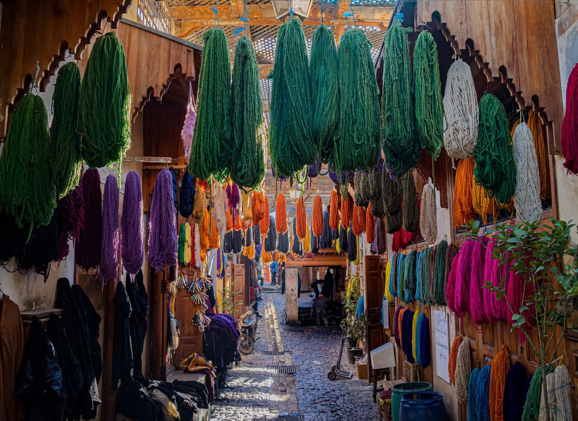 Colorful textiles and fabrics displayed in the traditional souk of Fez, Morocco