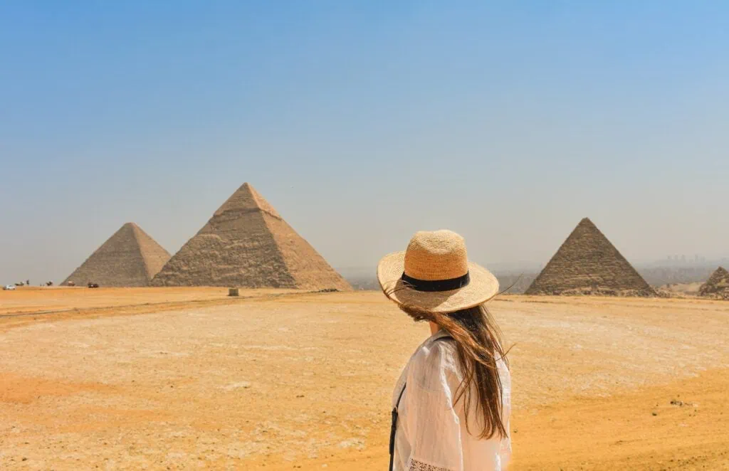 A woman standing at a viewpoint facing the Giza Pyramids, Giza Pyramids, Giza