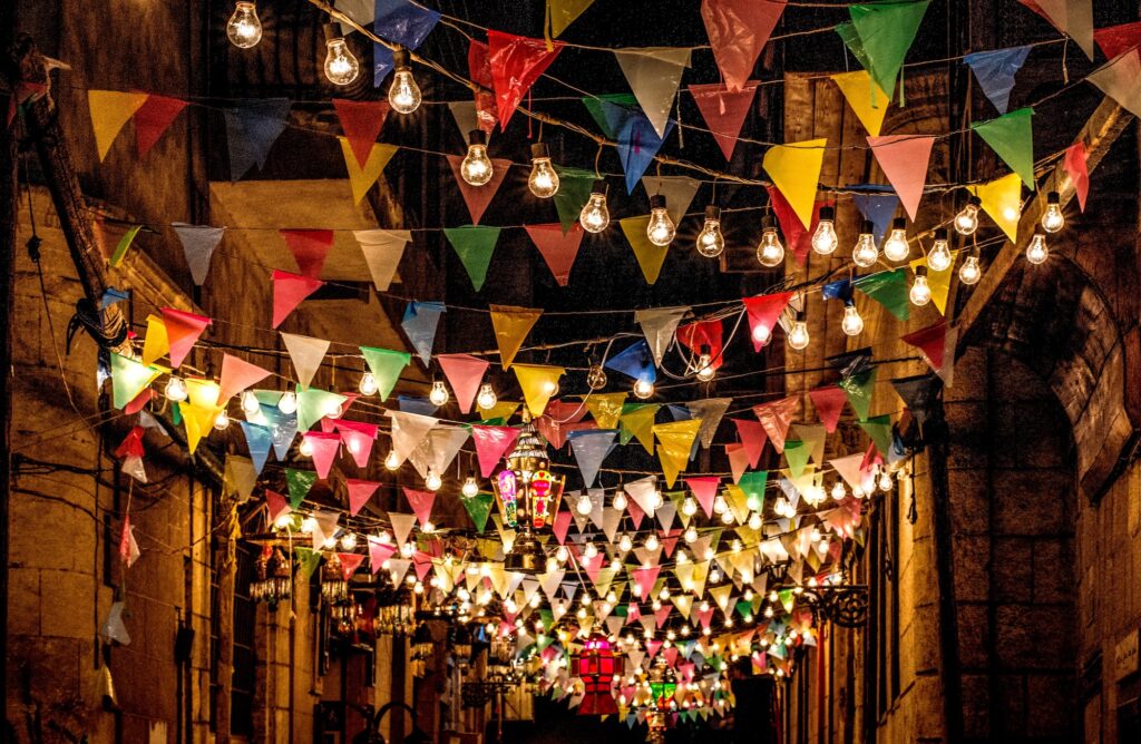 Lanternas e faixas coloridas de Ramadã penduradas acima de uma rua estreita do Cairo Antigo