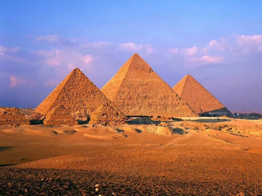 The Giza pyramid complex on the desert plateau outside Cairo, with the pyramids rising from the sand under a clear sky, Egypt.