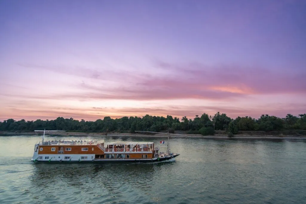 A Dahabiya Nile Cruise sailing towards Esna Lock on the Nile at dusk, between Luxor and the southern temples of Egypt