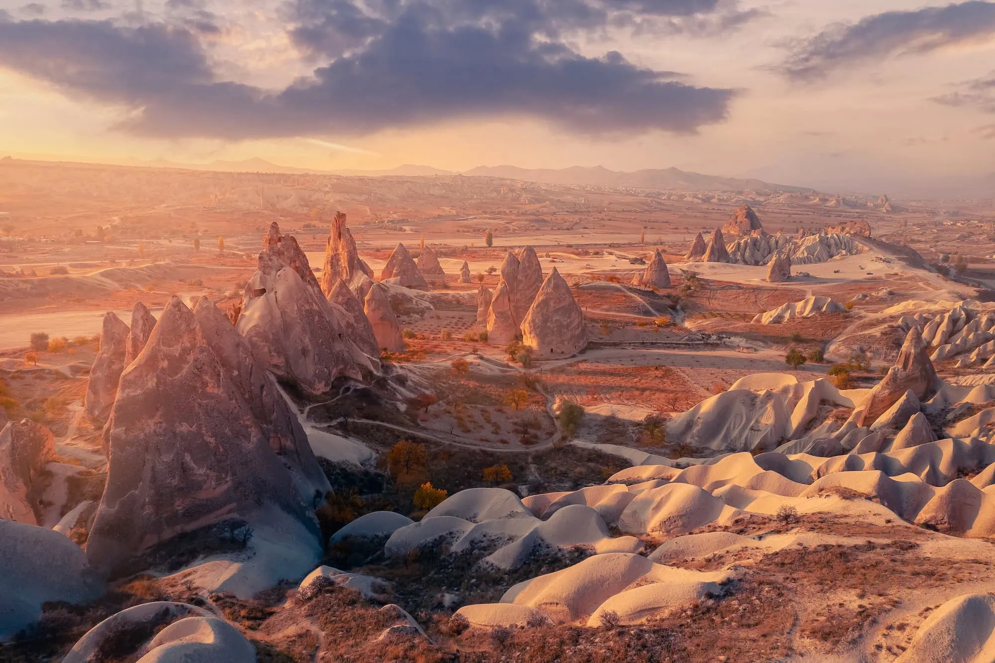 Aerial sunset view of Cappadocia's fairy chimneys bathed in golden light