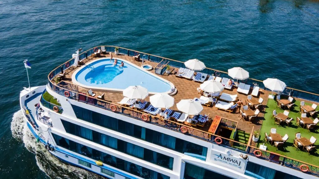 Aerial view of the rooftop sun deck and swimming pool of a Luxury Nile Cruise vessel docked at Luxor, Egypt — multi-deck 5-star vessel with panoramic cabins, sailing the Luxor–Aswan route