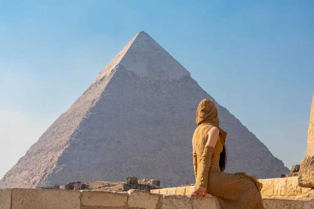 Back view of a woman facing the Great Pyramids of Khufu and Khafre on the Giza Plateau, Giza