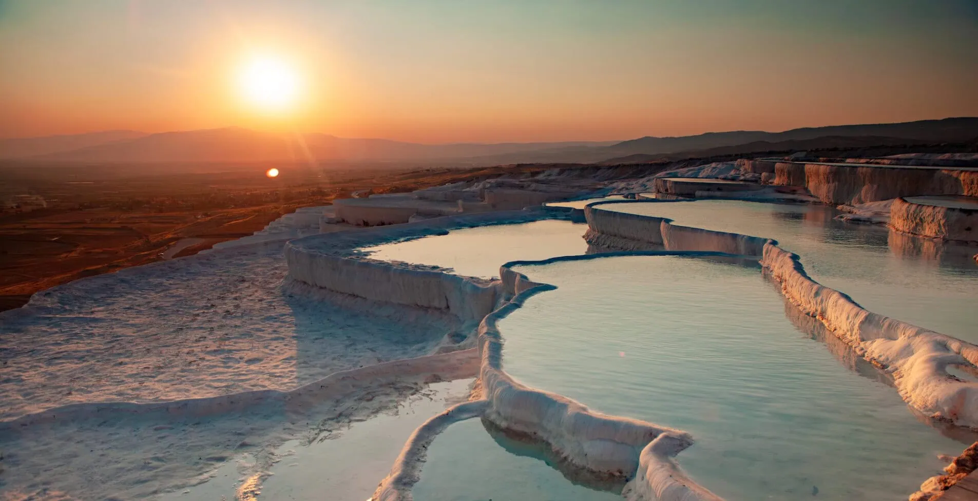 Captivating sunset over Pamukkales natural travertine terraces filled with turquoise thermal water 1905x976 crop 52 55