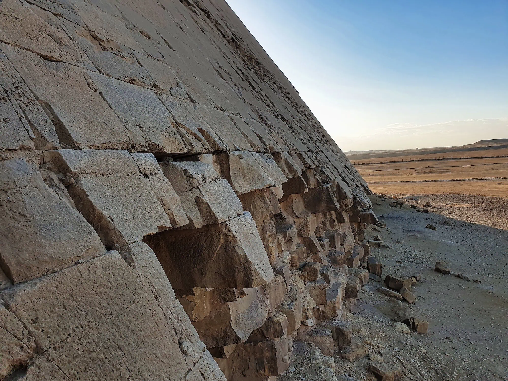 A close-up view of the massive limestone blocks forming the Great Pyramid of Khufu on the Giza plateau, showing the scale of each stone, Egypt.