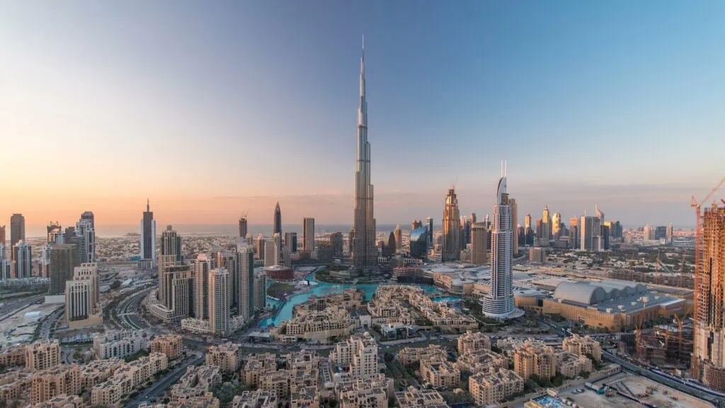 Downtown Dubai at twilight with Burj Khalifa and surrounding high-rise towers transitioning from day to night — the modern-luxury anchor of every Egypt and Dubai itinerary