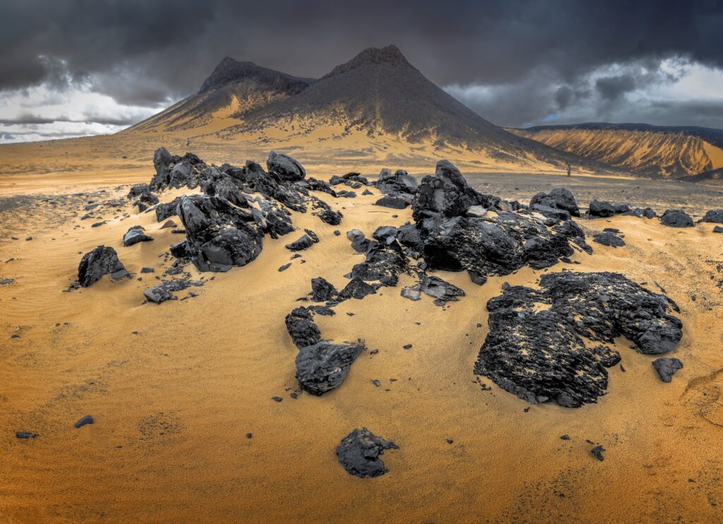 Volcanic black desert landscape with dark hills and barren terrain
