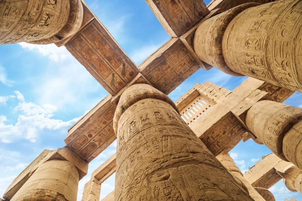 The columns of the Great Hypostyle Hall at Karnak Temple seen from ground level looking up toward the sky, at ancient Thebes in Luxor, Egypt.
