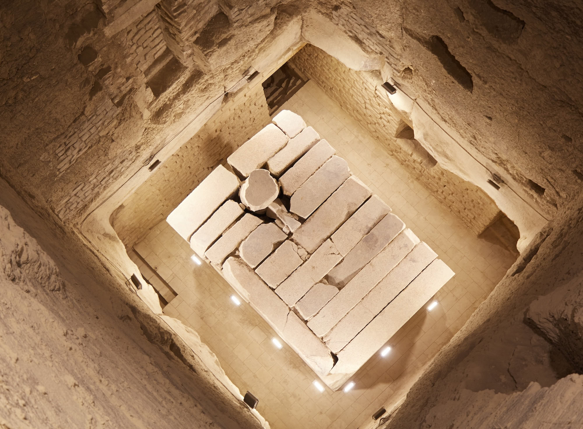 Ancient burial chamber beneath Step Pyramid with stone blocks and sarcophagus