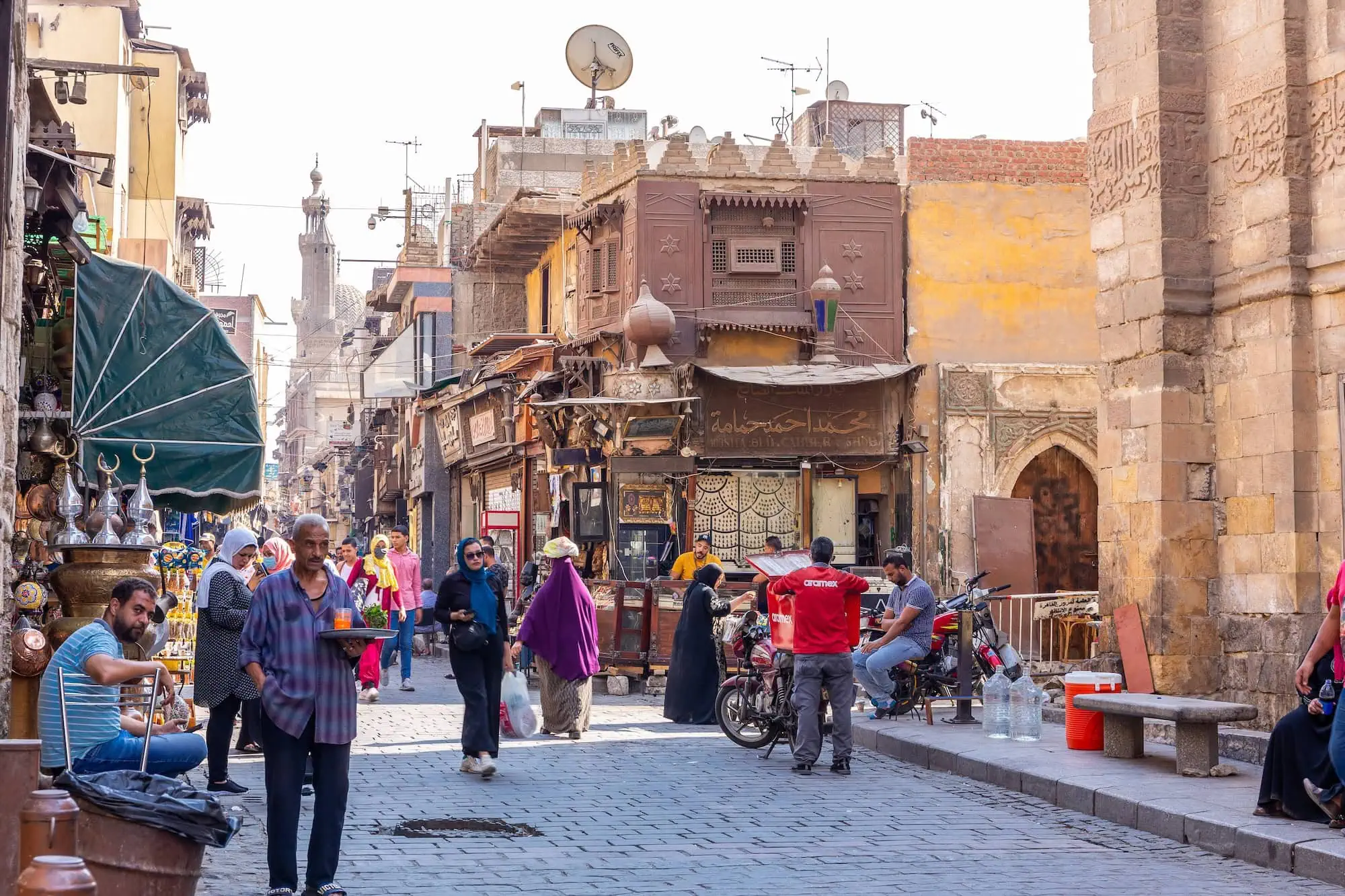 Family exploring the bustling Khan el-Khalili bazaar in Cairo with traditional architecture and market stalls