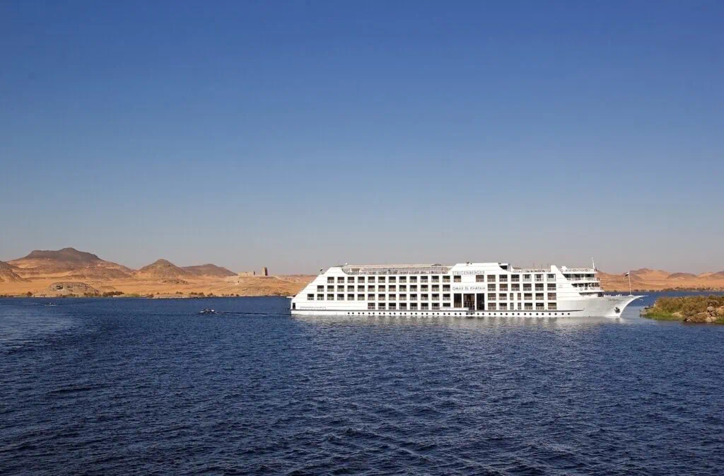 Lake Nasser cruise boat with Temple of Kalabsha on the shoreline, Aswan