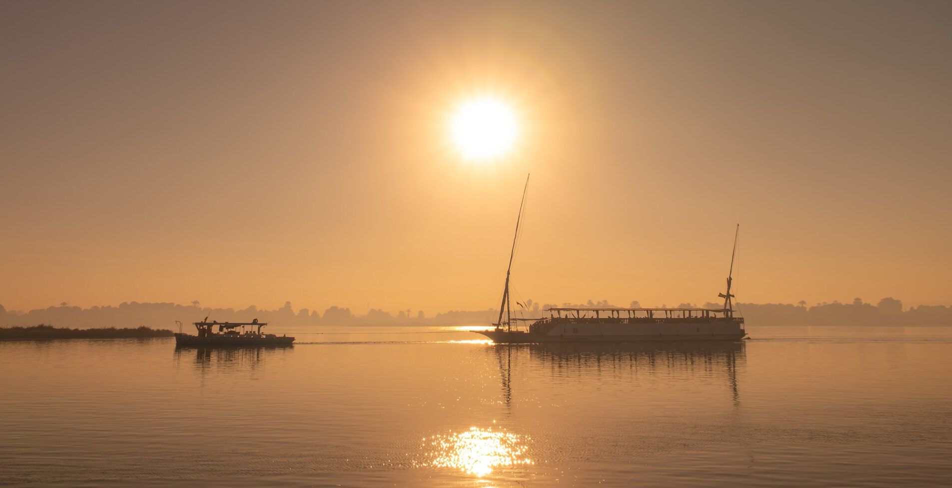 Silhouette of a traditional egyptian dahabiya boat cruising on the Nile river at sunset Egypt 1905x976 crop 50 74