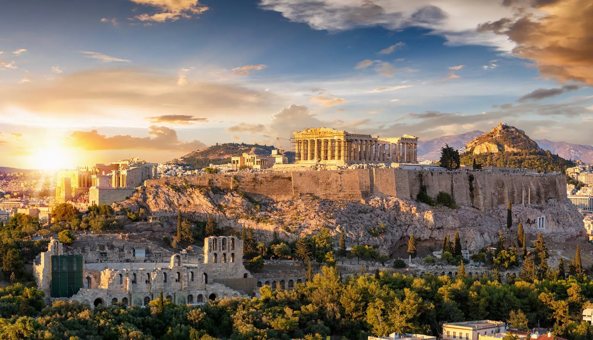 Sunset view of the Acropolis of Athens with the Parthenon temple illuminated on a hilltop