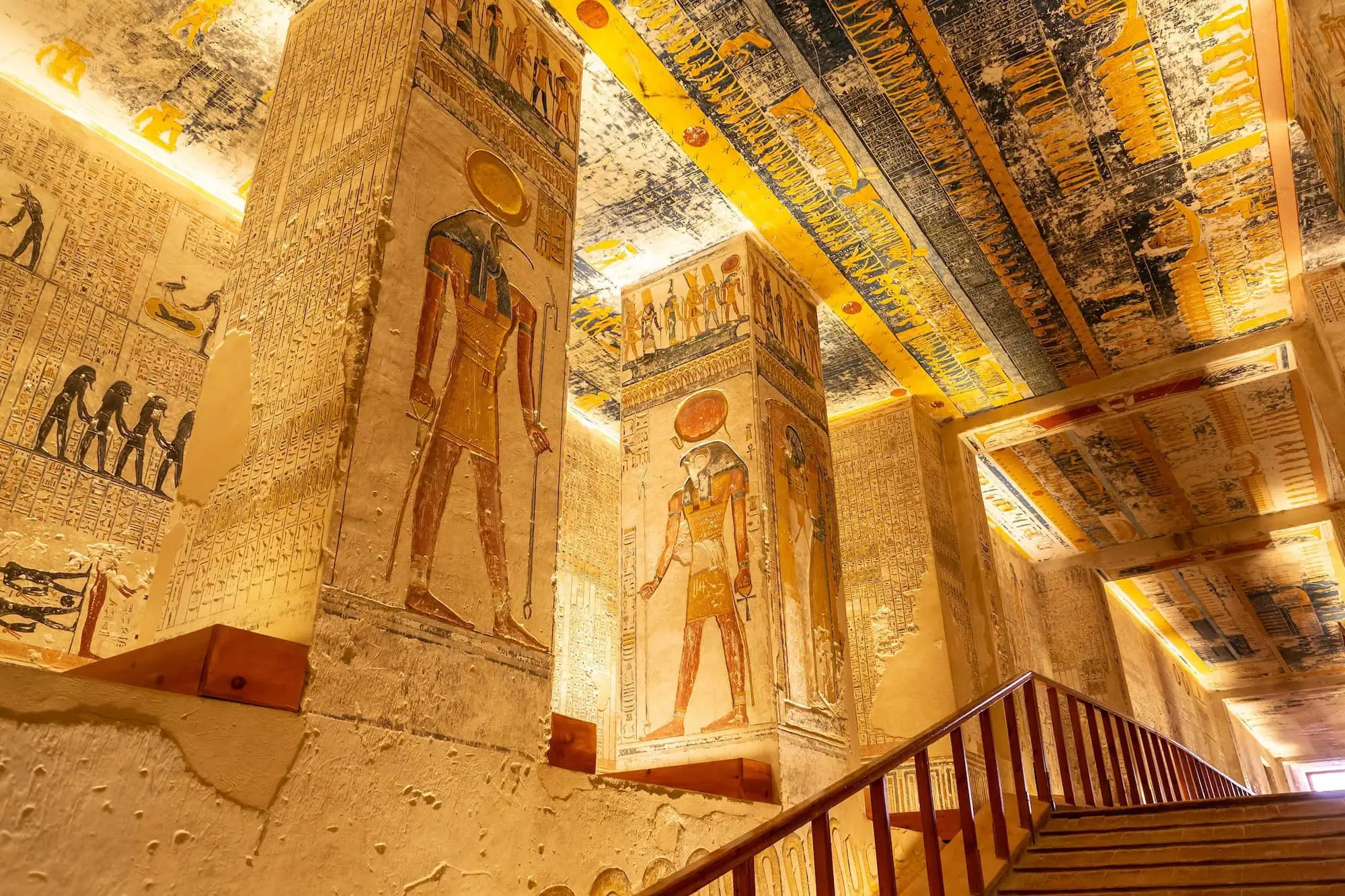 The interior of a rock-cut royal tomb in the Valley of the Kings, with brightly painted hieroglyphics and murals covering the walls and ceiling, Luxor, Egypt.