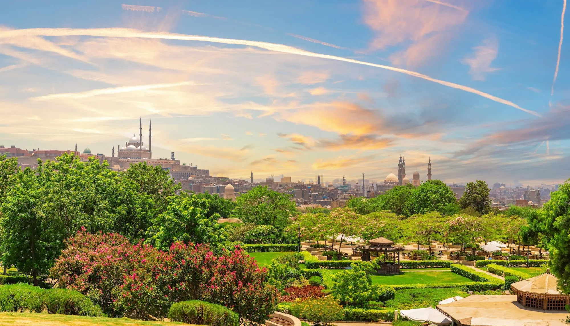Panoramic view of Al-Azhar Park with landscaped gardens overlooking Cairo's historic cityscape and mosques