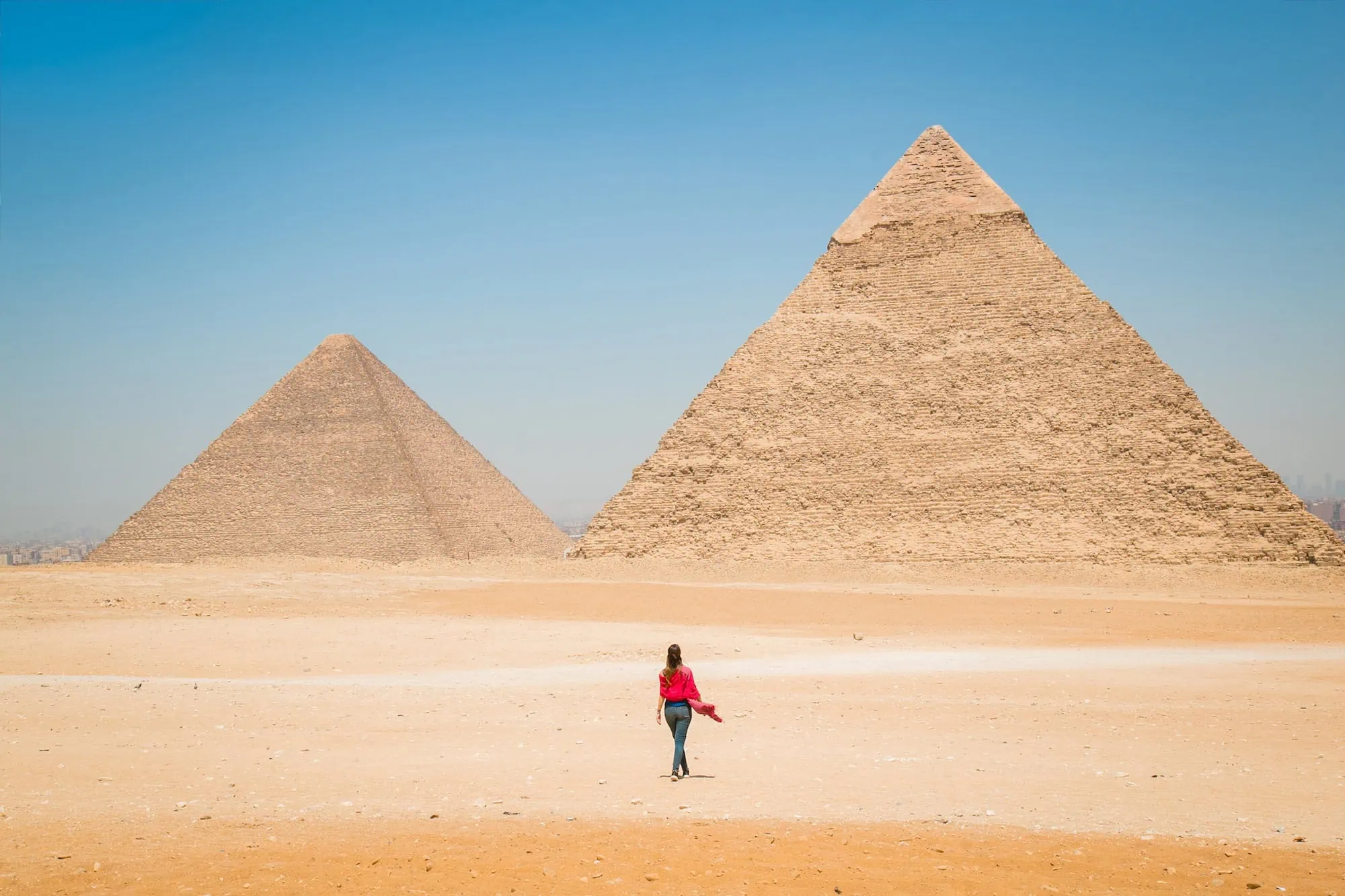 Traveler walking toward the Great Pyramids of Giza on the Giza Plateau, Giza