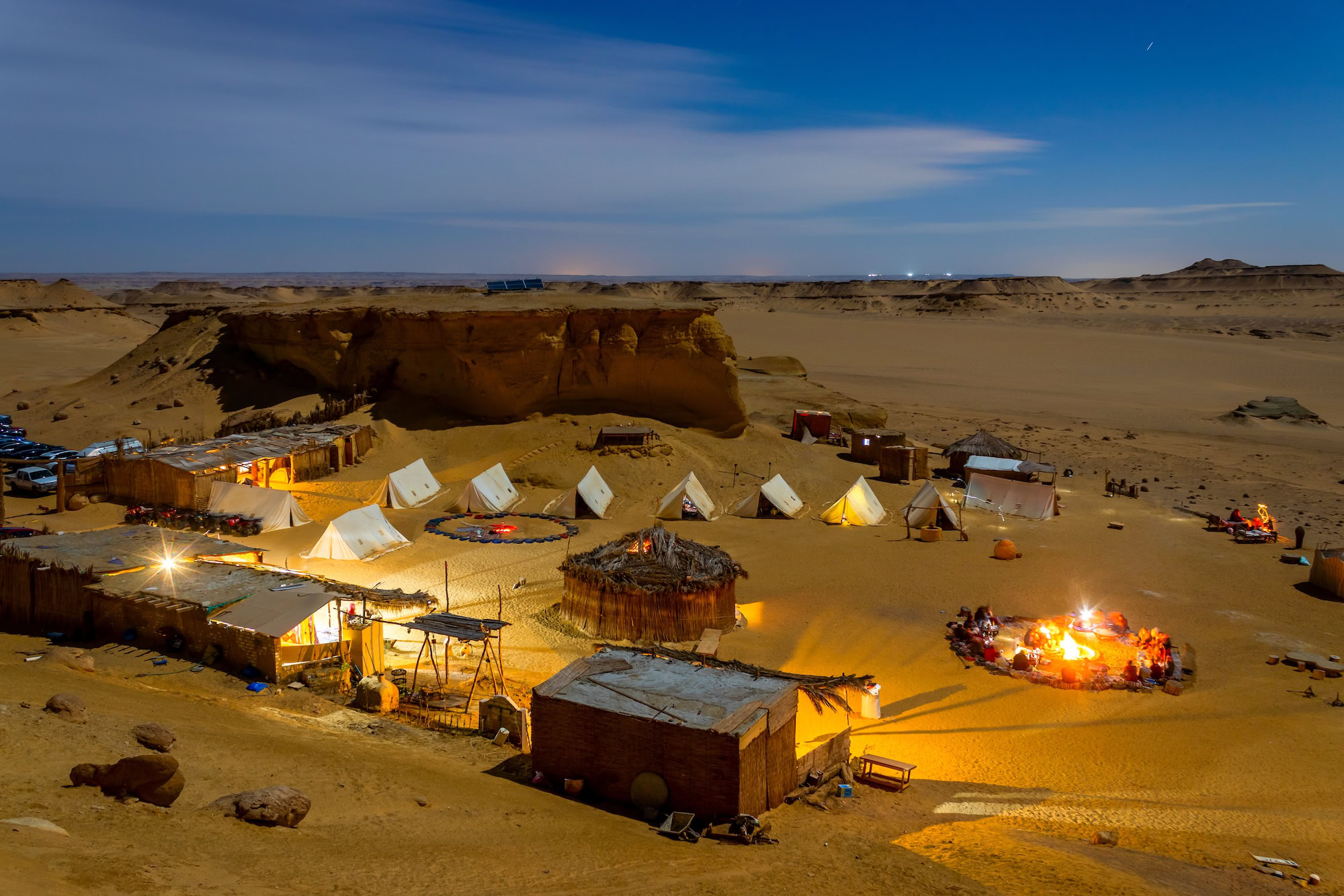 Campamento mágico en el desierto del Sahara con tiendas iluminadas y dunas de arena