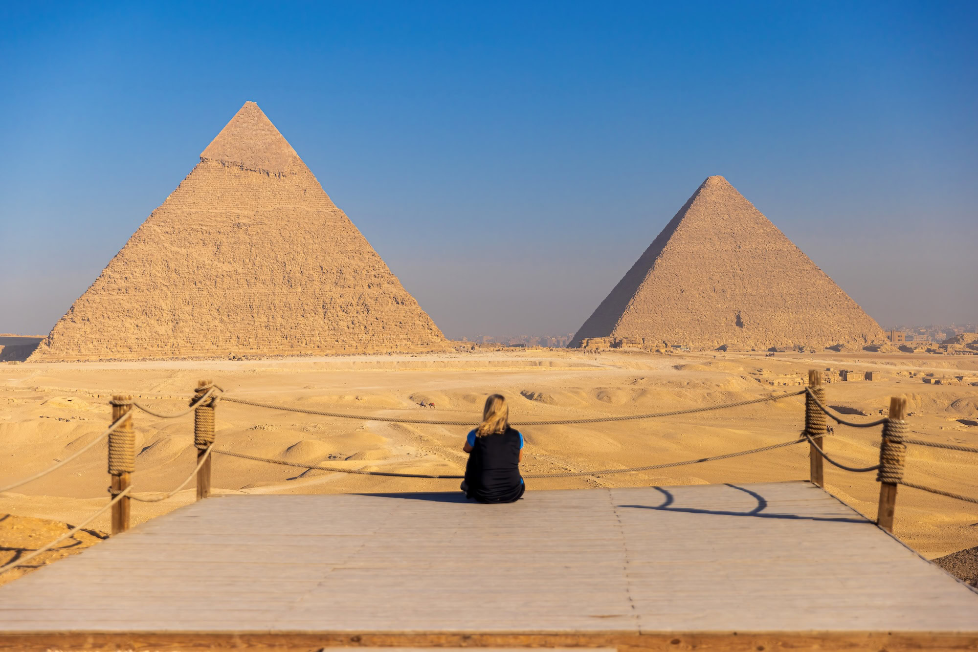 Tourist sitting in front of the Pyramids of Giza