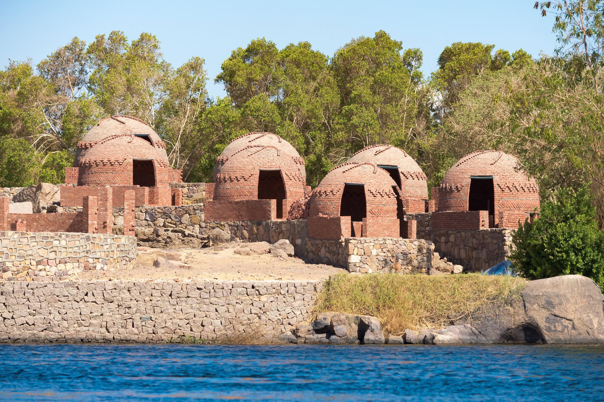 Ancient Nubian village ruins with domed brick buildings near a river