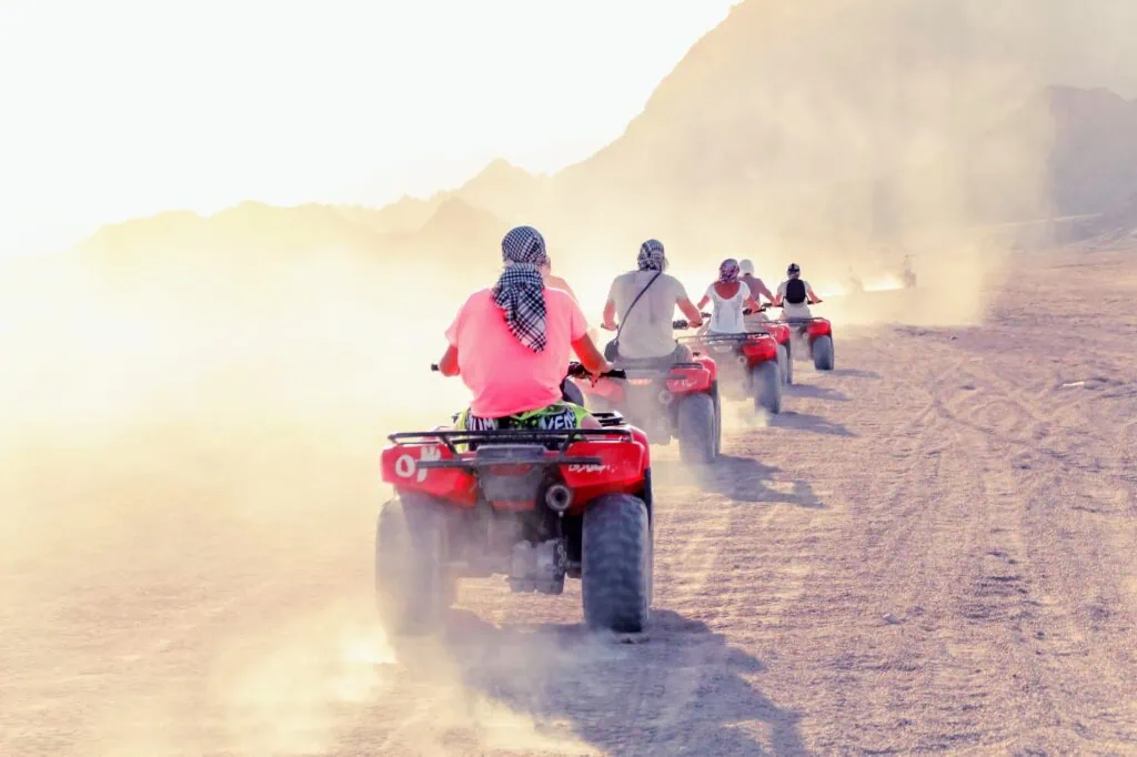 Quad bikes across a wide desert landscape