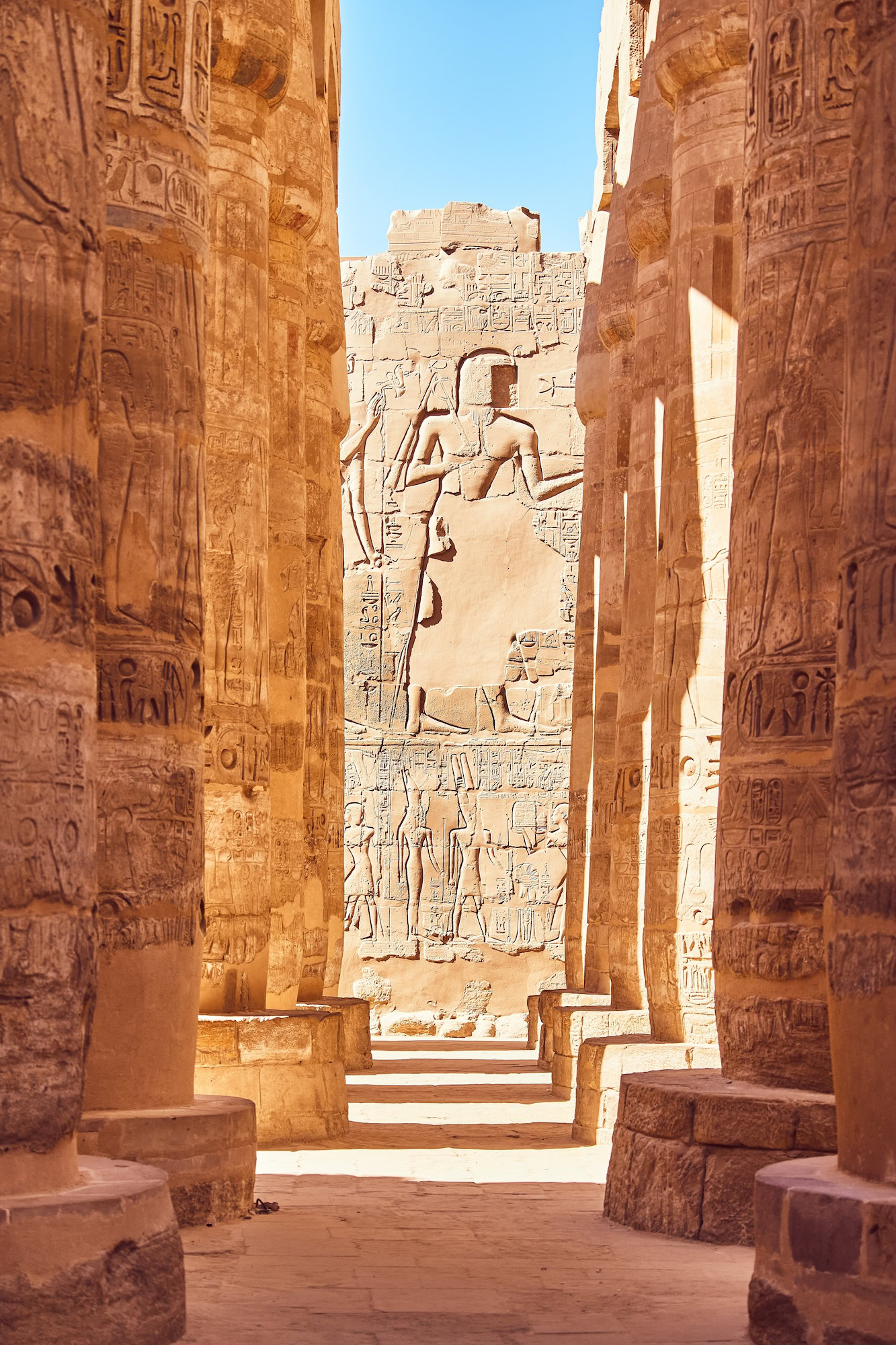 Ancient columns with hieroglyphics and pharaoh statue at Karnak Temple Complex