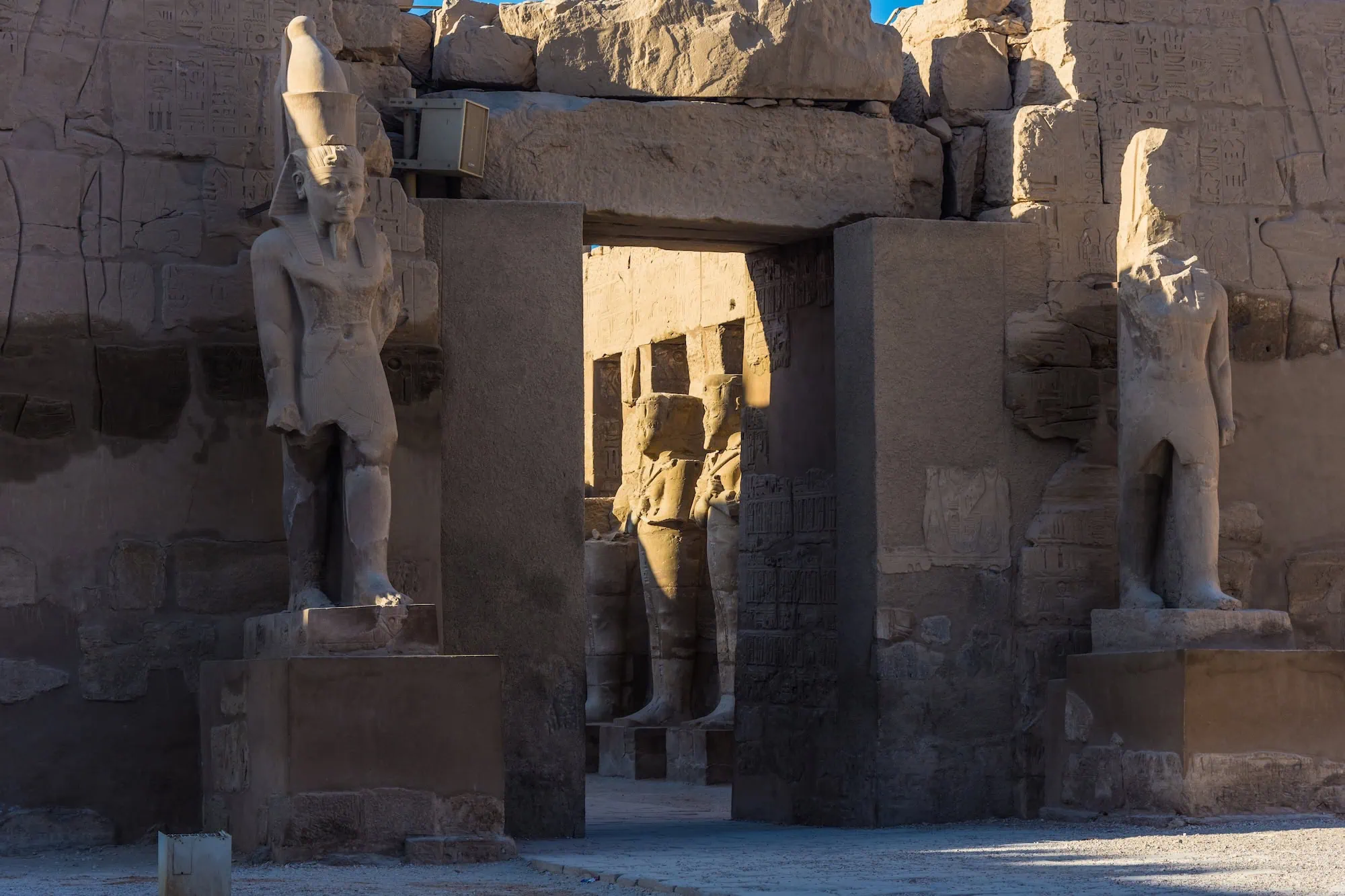 Massive pharaoh statues flanking entrance of Karnak Temple Complex