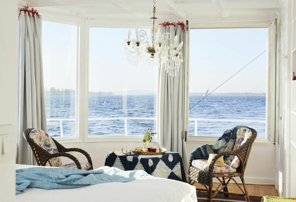 Elegant luxury Nile cruise ship cabin interior with ornate chandelier and river view