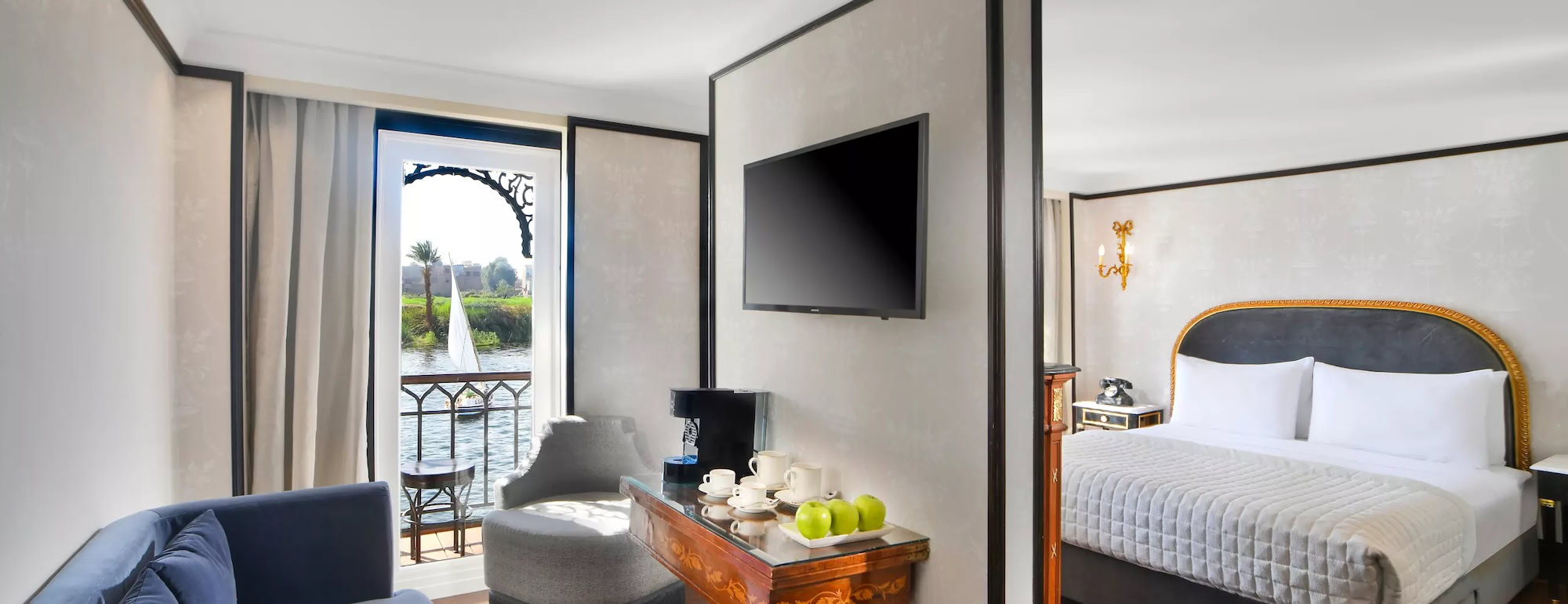 Quarto luxuoso de hotel no Egito com televisão e varanda com vista para o Rio Nilo