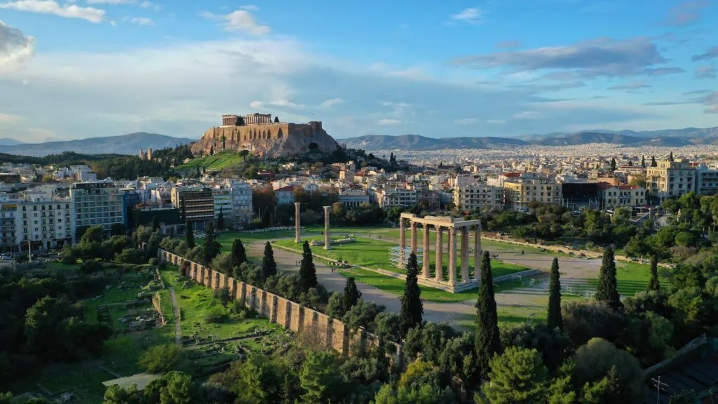 Aerial view of the Temple of Olympian Zeus at sunset with the Acropolis hill and the Parthenon in the background, Athens, Greece, a city often paired with Egypt on multi-country tours.