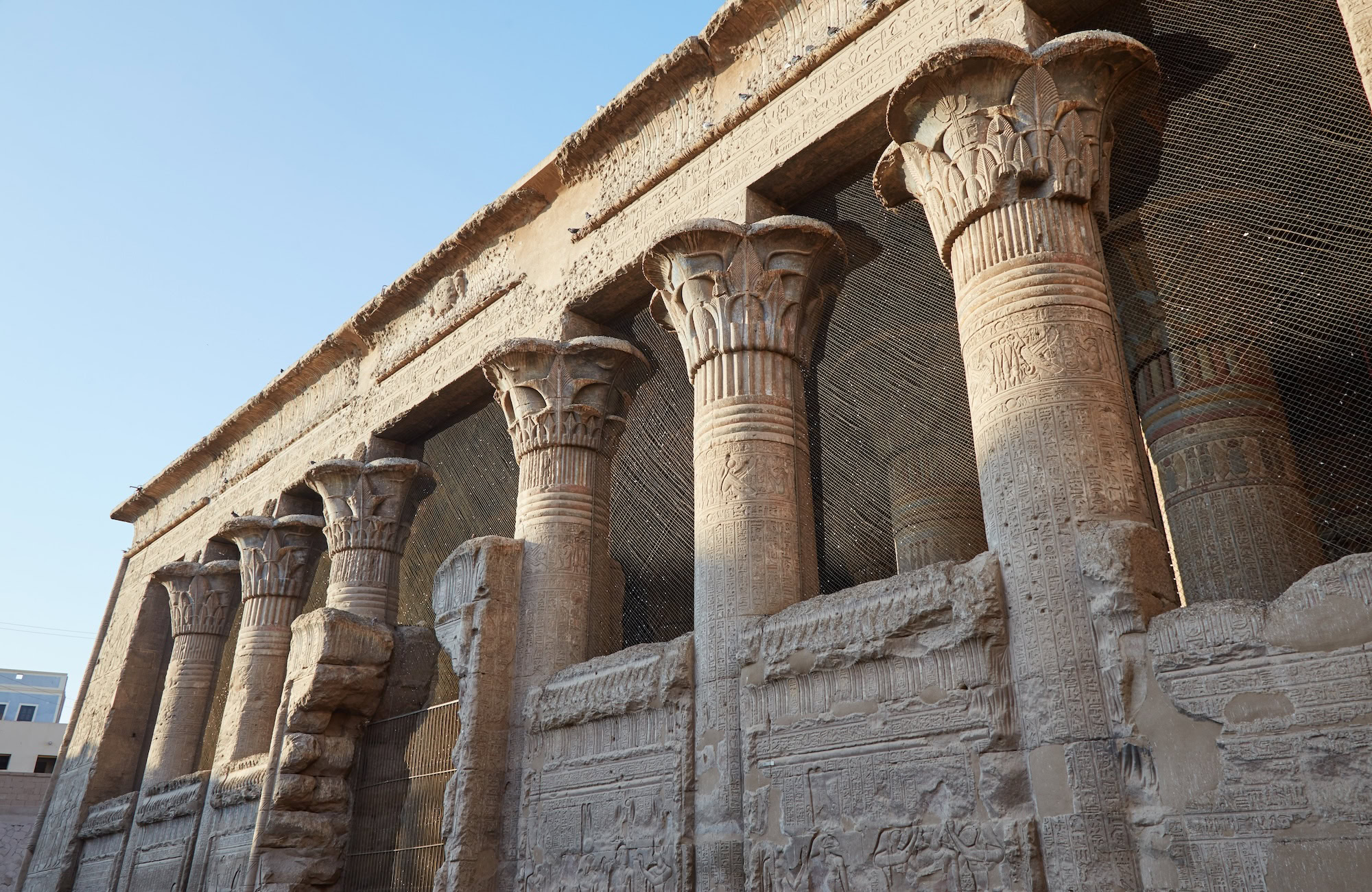 Colunas do Templo de Dendara com hieróglifos e relevos coloridos preservados