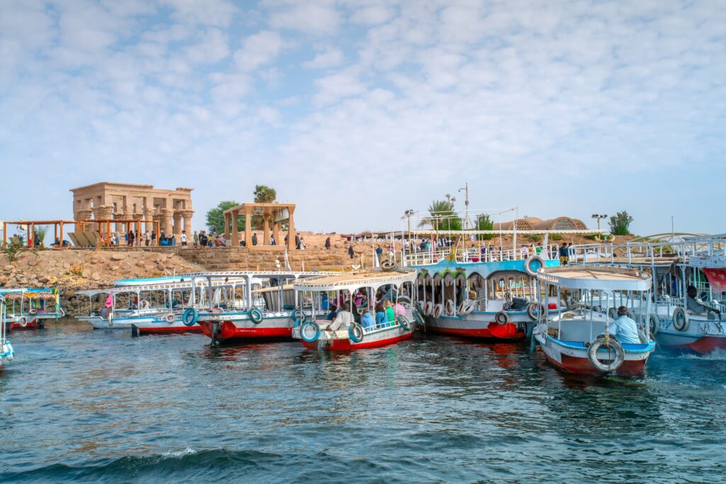 Tourists arriving by boat at Philae Temple across Lake Nasser
