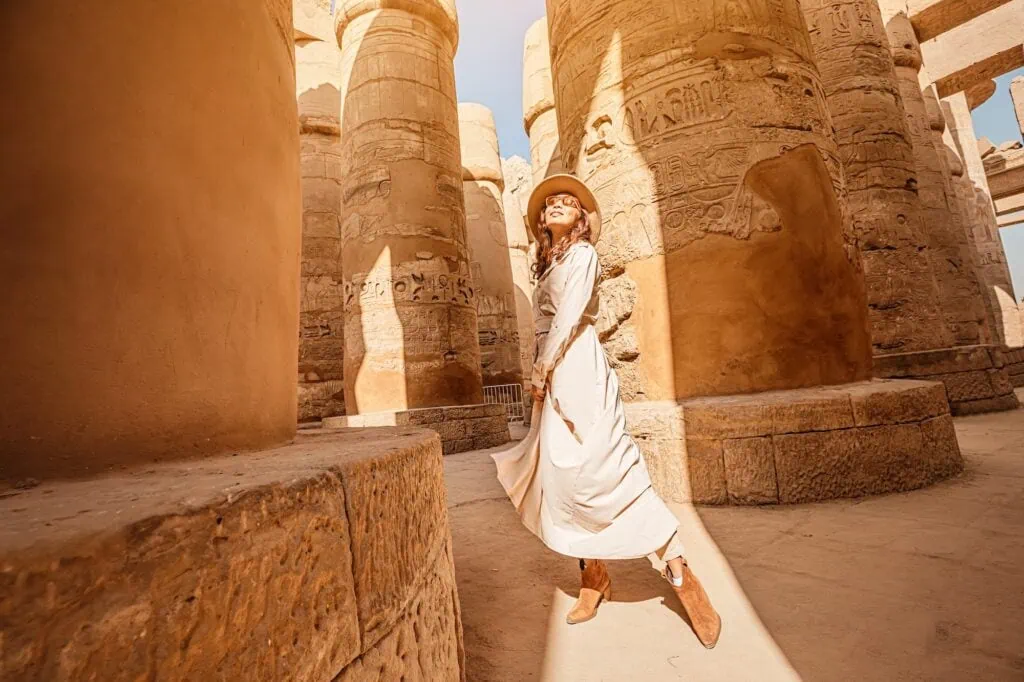 Traveler exploring the hypostyle hall columns of Karnak Temple