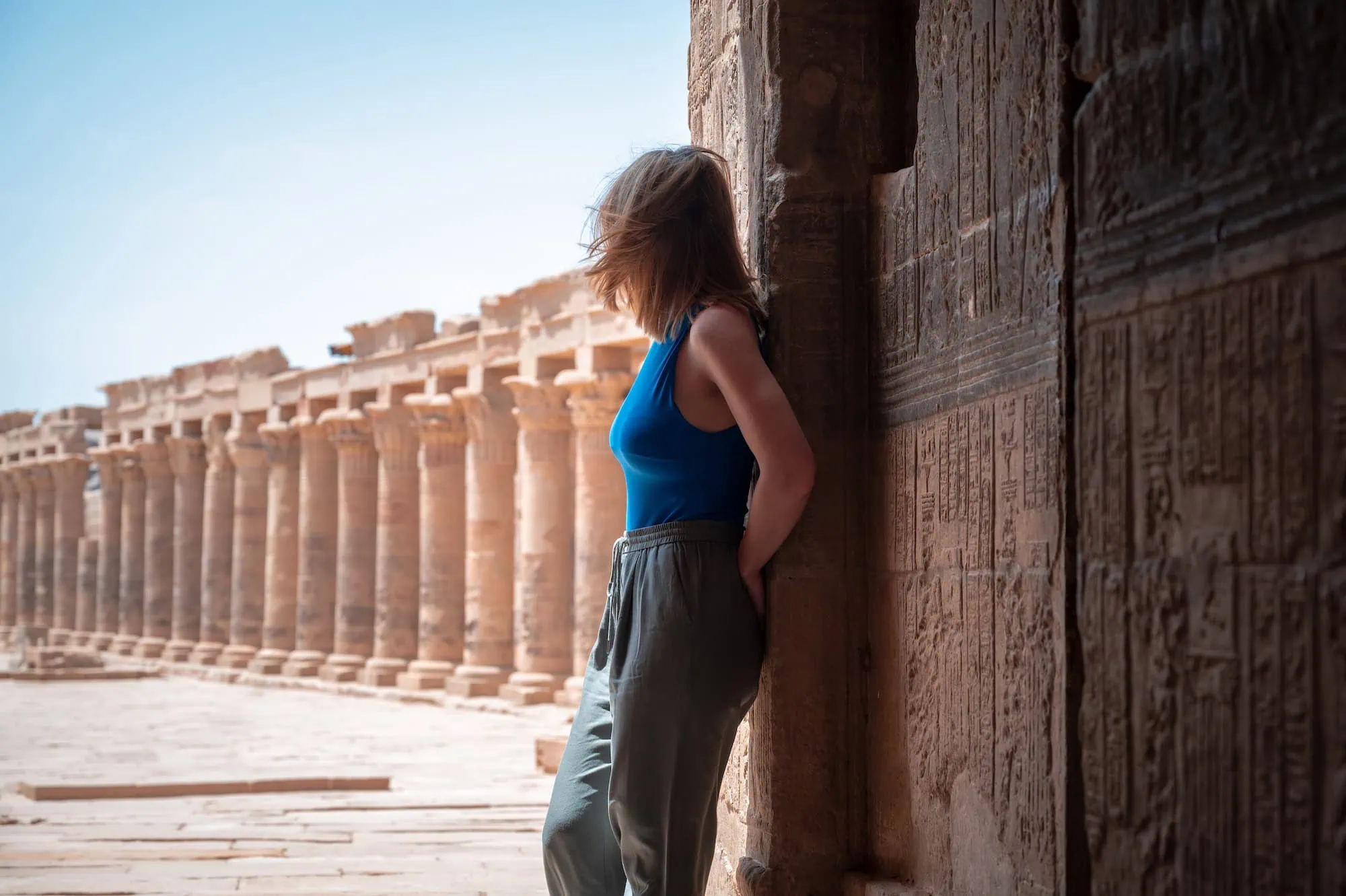 Donna che visita un antico tempio egiziano con abbigliamento modesto e rispettoso