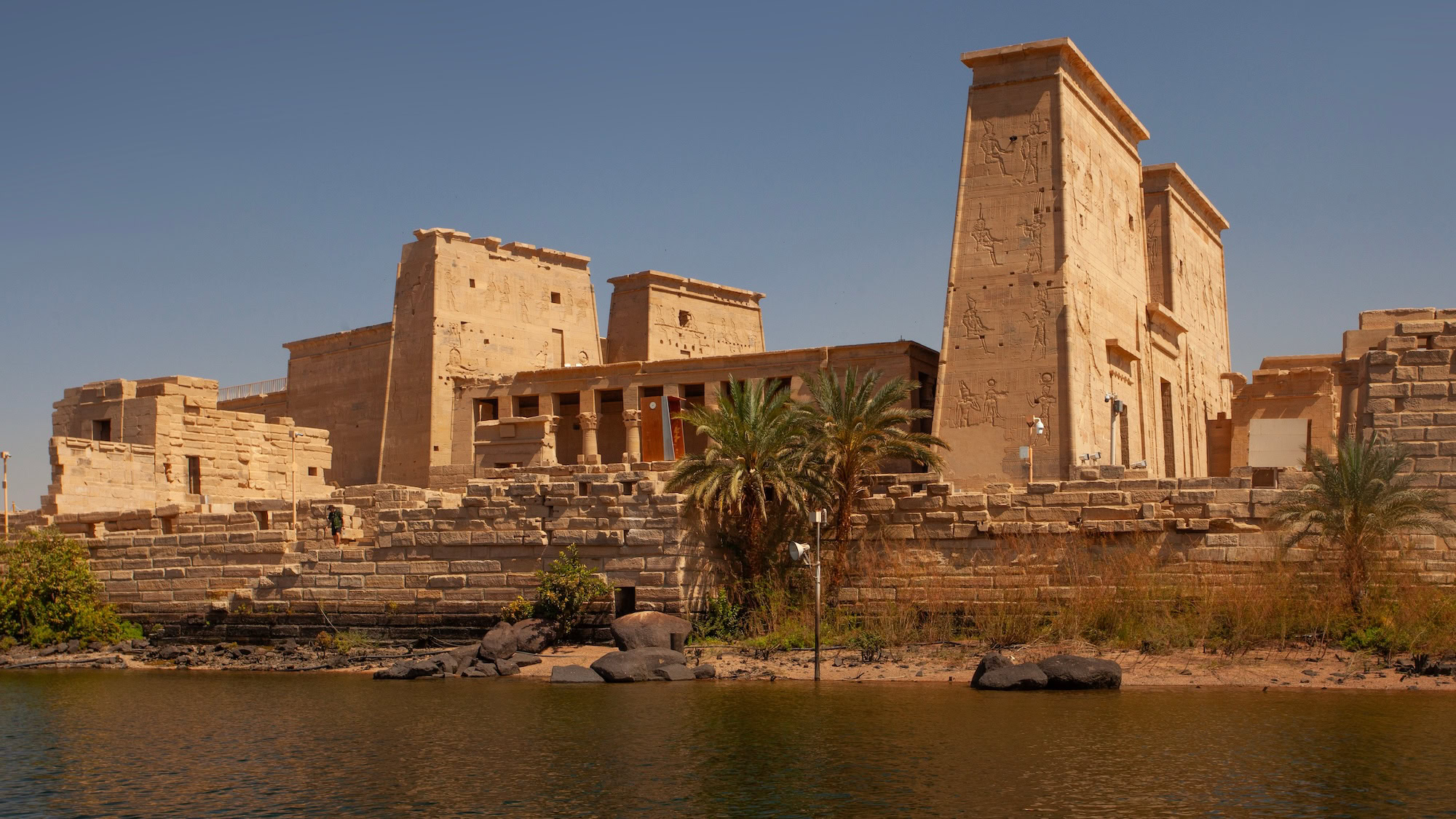 Temple of Philae ancient ruins with columns and hieroglyphs beside water in Aswan