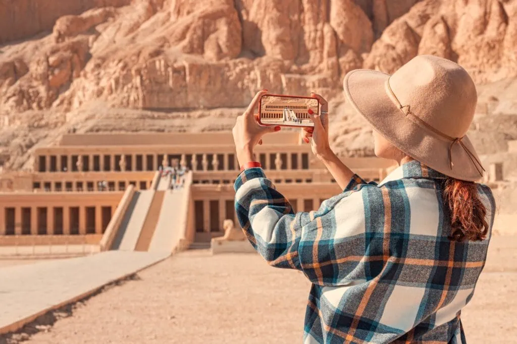 Tourist photographing Hatshepsut Temple with her phone