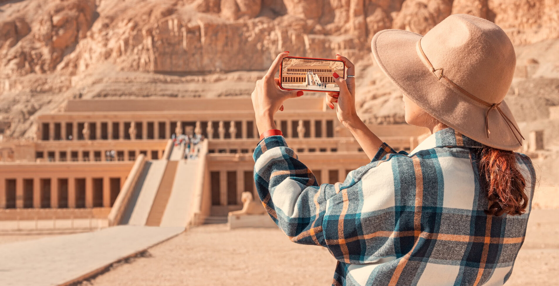 girl takes pictures on a smartphone at the famous Hatshepsut temple in the ancient city of Luxor in Egypt 1905x976 crop 20 53