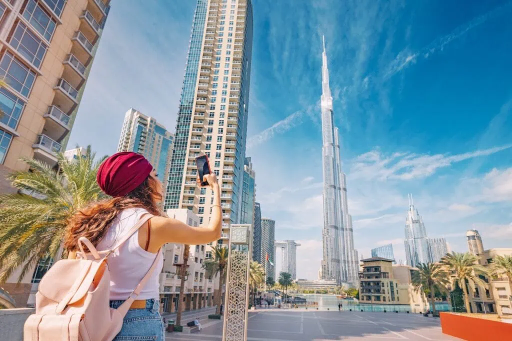 Tourist taking photos with Burj Khalifa towering in the background, Dubai