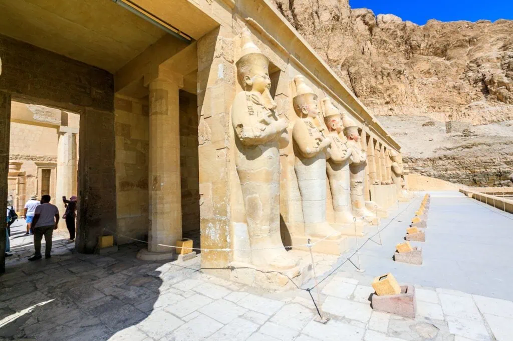 Statues of pharaohs lining the second terrace of Hatshepsut Temple at Deir el-Bahari, Luxor