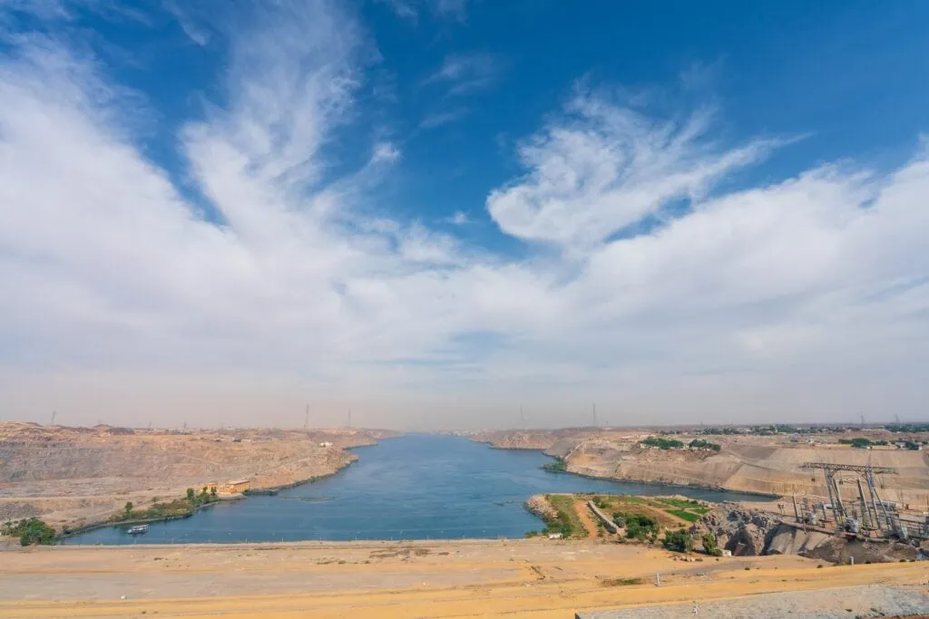 Aerial view of the High Aswan Dam stretching across the Nile, with Lake Nasser to the south and desert beyond