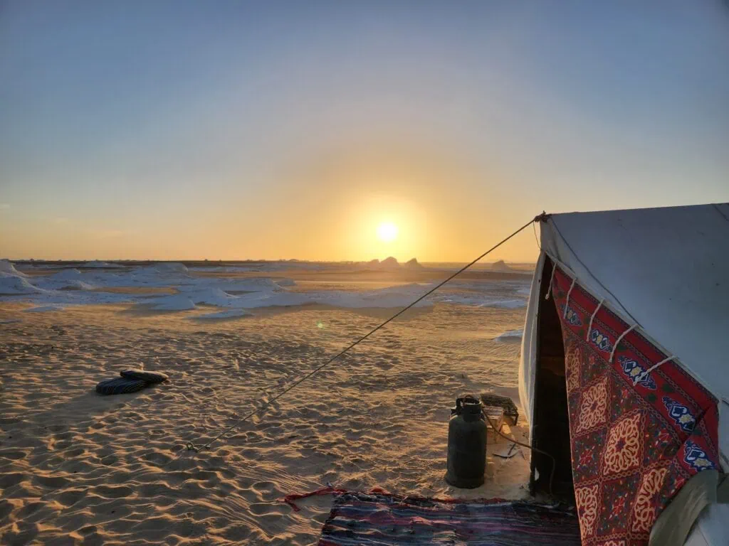 Desert camping tents set among white limestone rock formations in the White Desert, Farafra