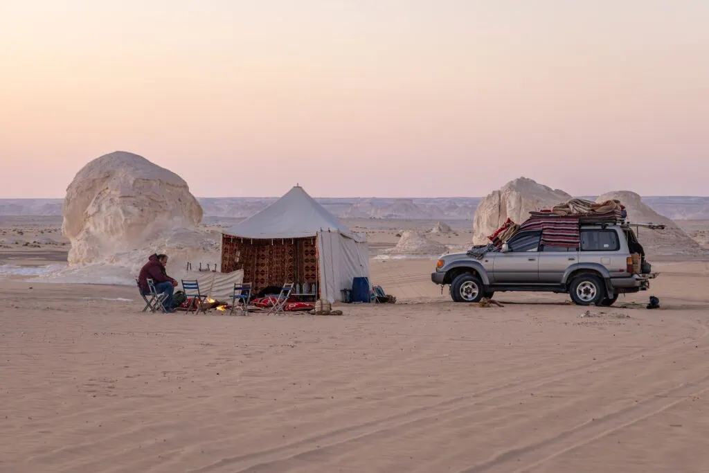 Tents pitched among white chalk rock formations at a desert camp in the White Desert near Farafra, the kind of Western Desert overnight arranged on the adventure side of a guided Egypt trip.