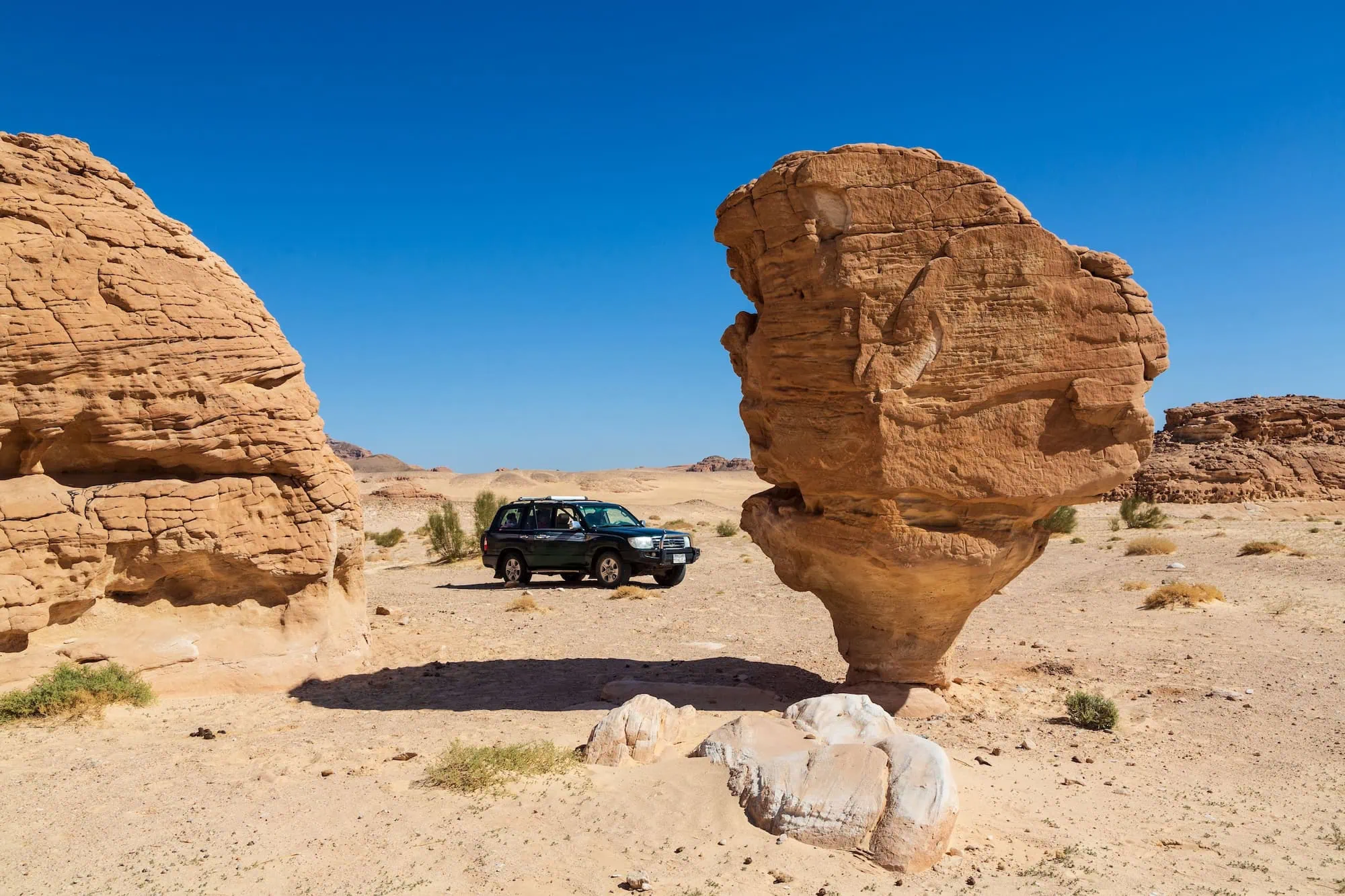 Mushroom-shaped sandstone rock formation in the Sinai Desert near Nuweiba with vehicle parked nearby