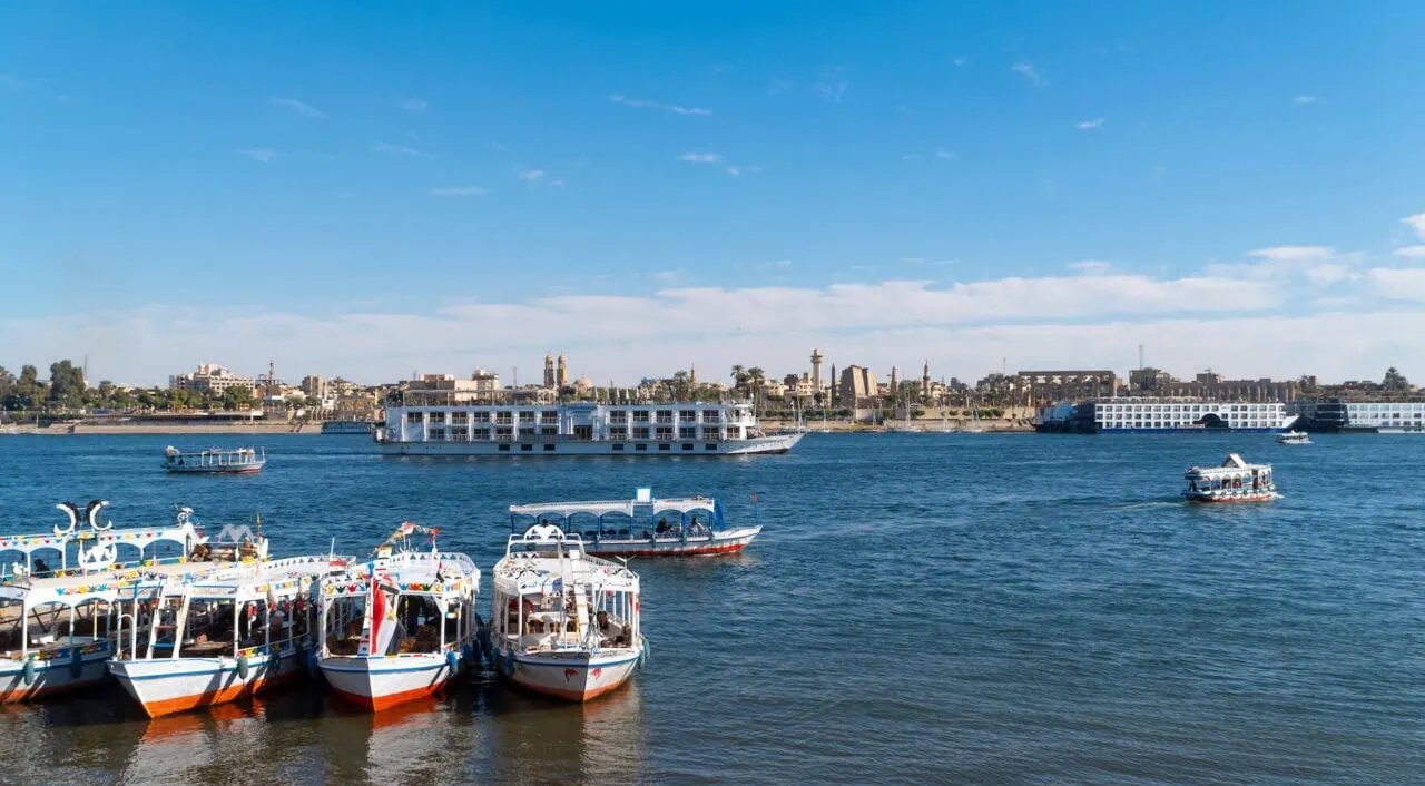 Nile embankment with boats and Luxor Temple in Luxor cruise ship